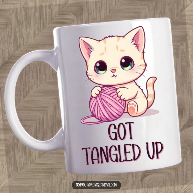 Funny mug showing a cute cat with huge, wide eyes, batting playfully at a tangled ball of colorful yarn.