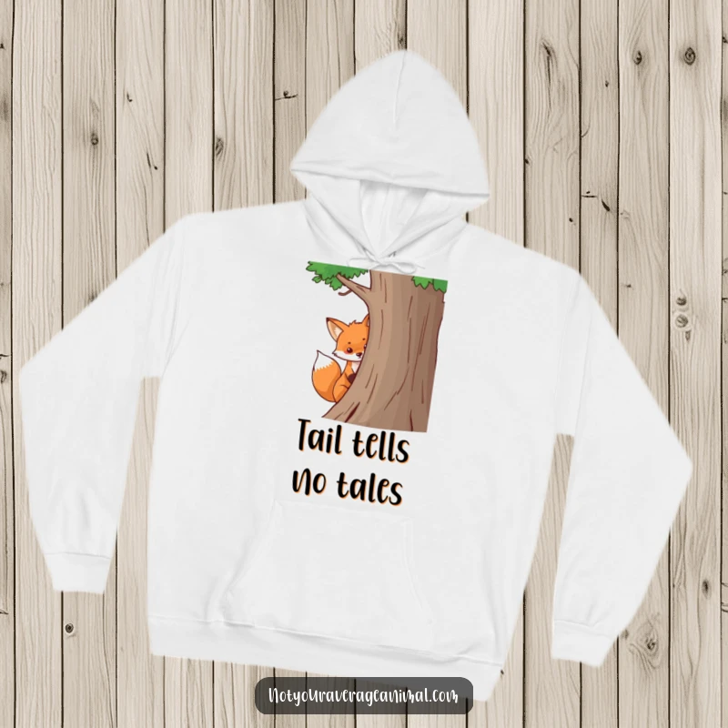 Funny fox hoodie with a bushy tail peeking mischievously from behind a tree, offering cozy and humorous woodland-themed apparel.
